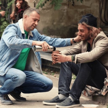 Man giving homeless guy some coffee